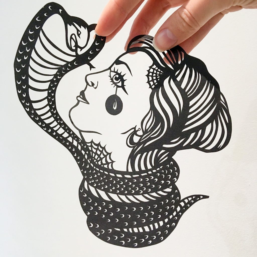 Papercut of a women with a snake wrapped around her throat