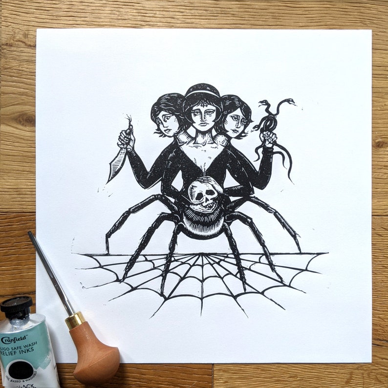 Lino print of a spider with three heads, all women